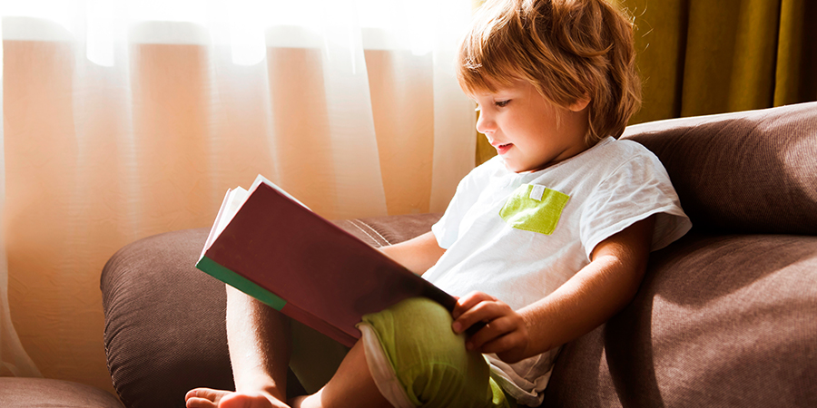 menino lendo e como tornar a alfabetização parte da rotina infantil